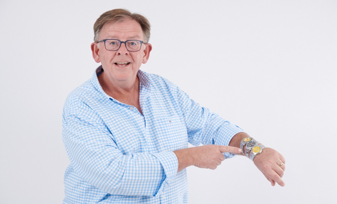 man in blue shirt pointing to three watches on his wrist