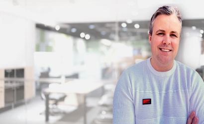 Smiling man with folded arms in an office